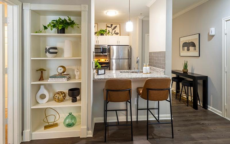 a kitchen with a dining counter next to shelves